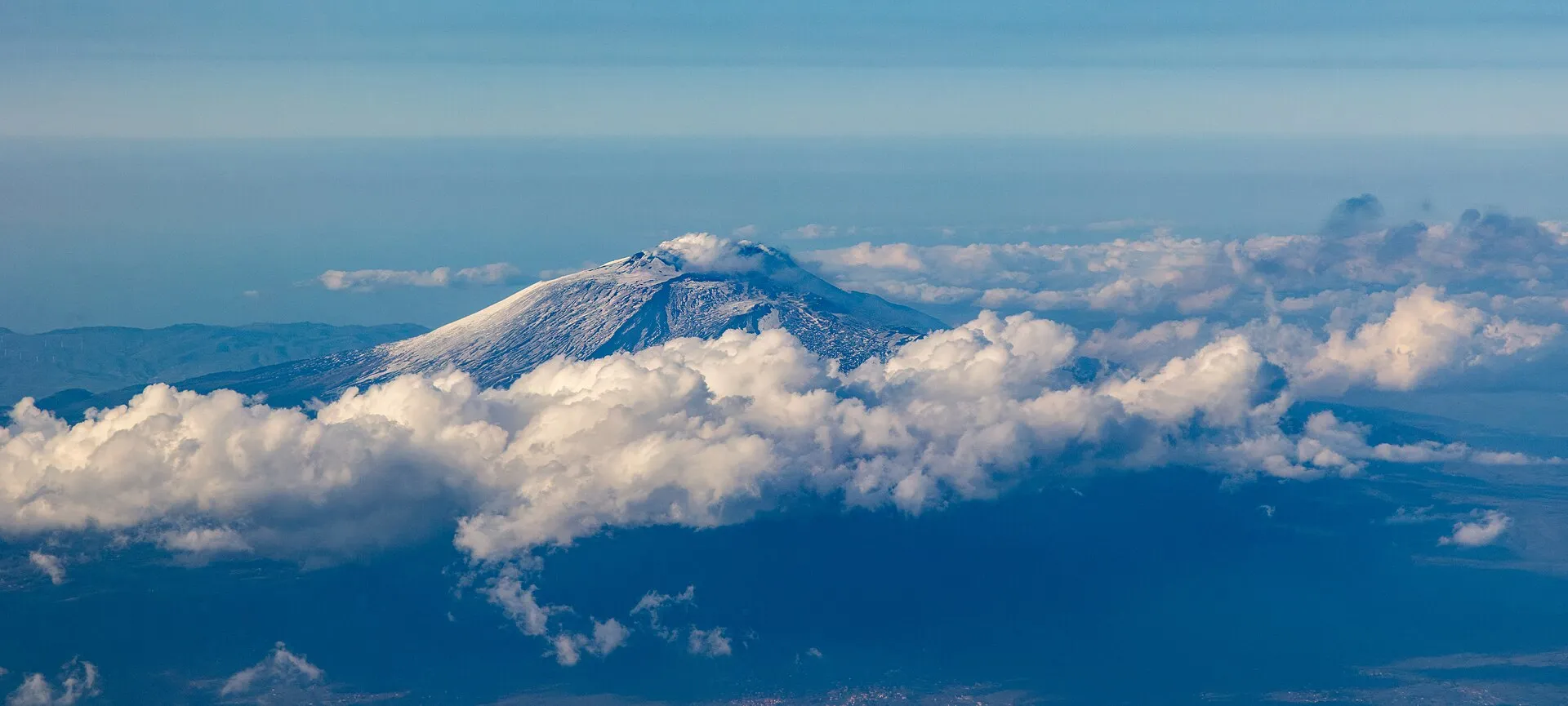 Paesaggio dell'Etna con terreno vulcanico e montagna