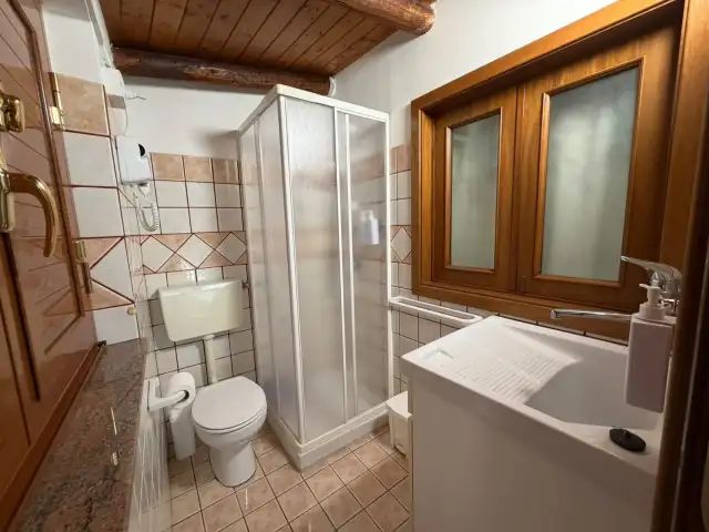 Secondo bagno di EtnAmore con doccia e soffitto in legno