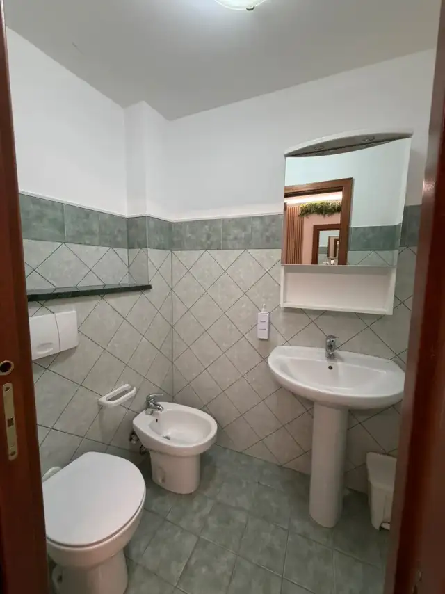 Uno dei due bagni di EtnAmore, con rivestimenti verdi